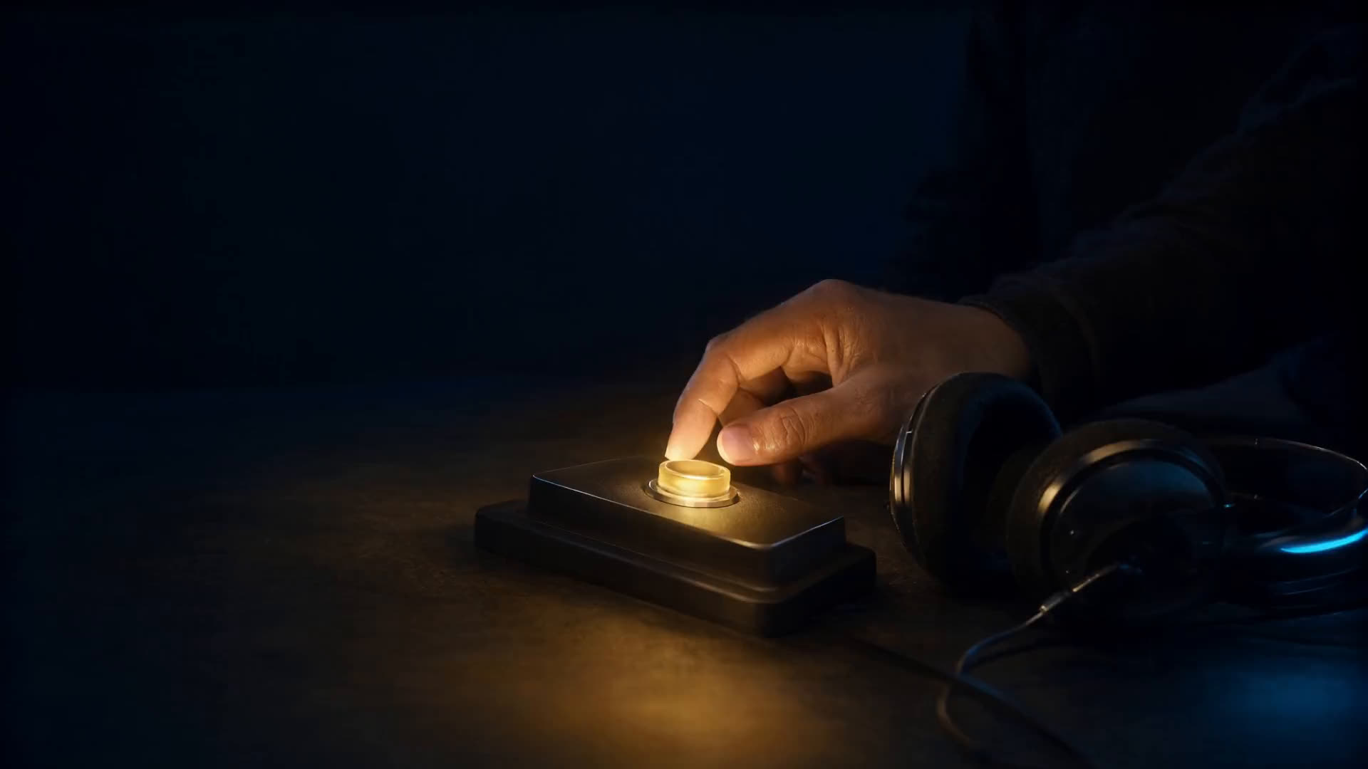 A hand answering a call on a glowing desk console